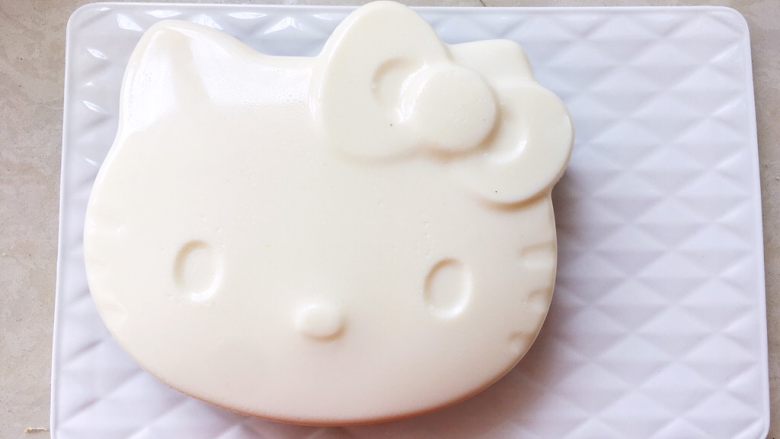 Hello kitty蜜豆牛奶冻,将模具倒扣在盘子上,轻拍底部,蜜豆牛奶冻就完美脱模啦,先将牛奶冻放入冰箱冷藏。