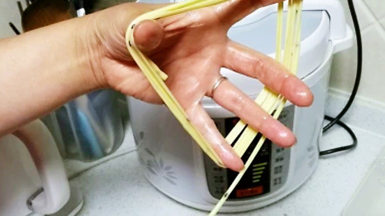 撒子,将醒发好的长条盘在手指上,一边绕,一边慢慢拉细