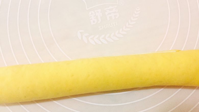 南瓜螺旋馒头,取出白色与黄色面团,分别擀成薄片,双色重叠后卷成长条