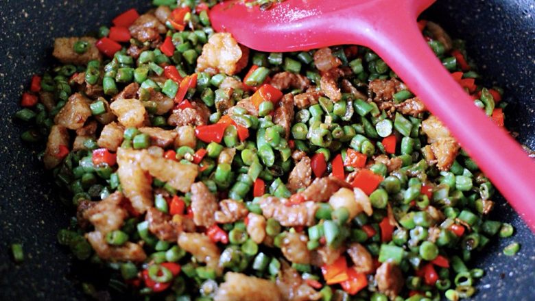 豆角酱肉发面包,健脾又消暑,加入豆角炒至变色断生后、加入红椒碎翻炒至变色断生即可