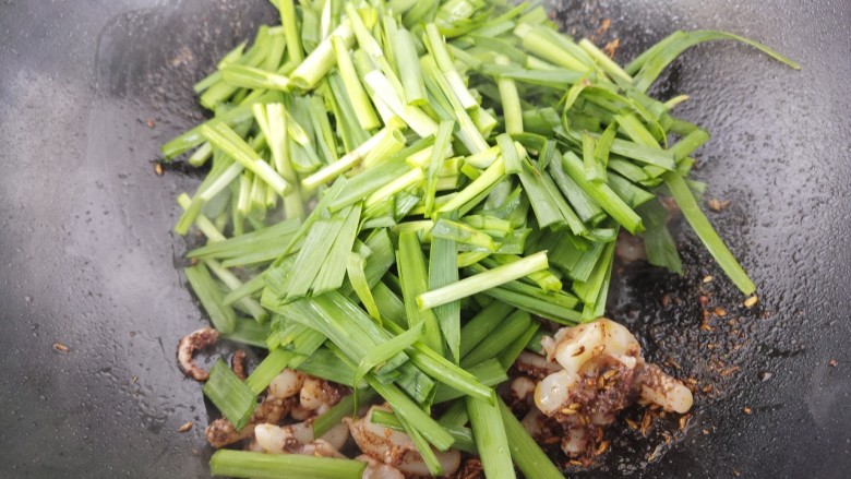 鱿鱼炒韭菜,鱿鱼炒熟,加入韭菜炒。