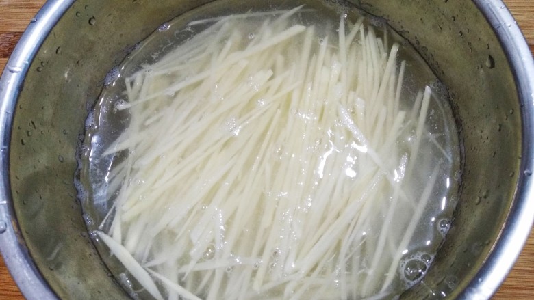 豆豉炝拌青椒土豆丝,切好的土豆丝泡水中,多洗几次洗干净淀粉。