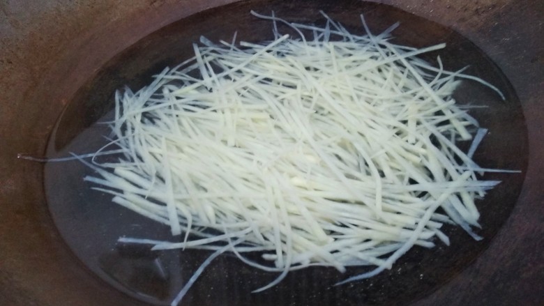 豆豉炝拌青椒土豆丝,水开后倒入土豆丝,焯水一分钟。