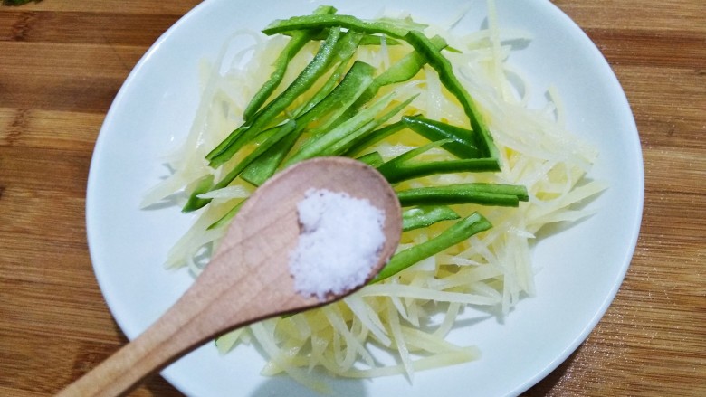 豆豉炝拌青椒土豆丝,烧油期间,放少许盐。