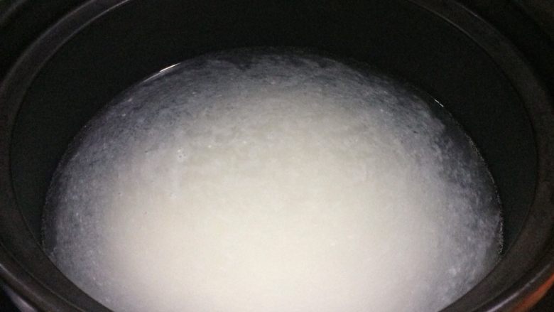 皮蛋瘦肉粥,砂锅放5到7碗水烧开,我用了6碗水。
倒入大米,重新烧开后转小火。
不时用汤勺捞一下底,以免大米粘锅。