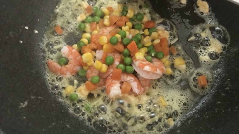 小朋友也爱吃的虾仁炒饭,倒入虾仁和杂蔬,翻炒均匀。