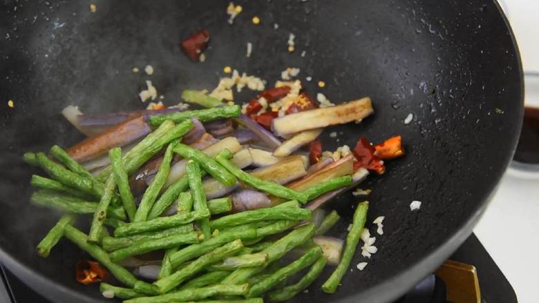 茄子和豆角放在一起烧，真的是美味又下饭,加入茄子、豇豆翻炒。
