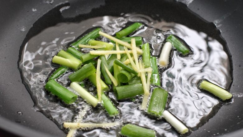 肉丝炒面,另起锅倒适量食用油烧至五成热,放入葱段和姜丝小火炒出香味
