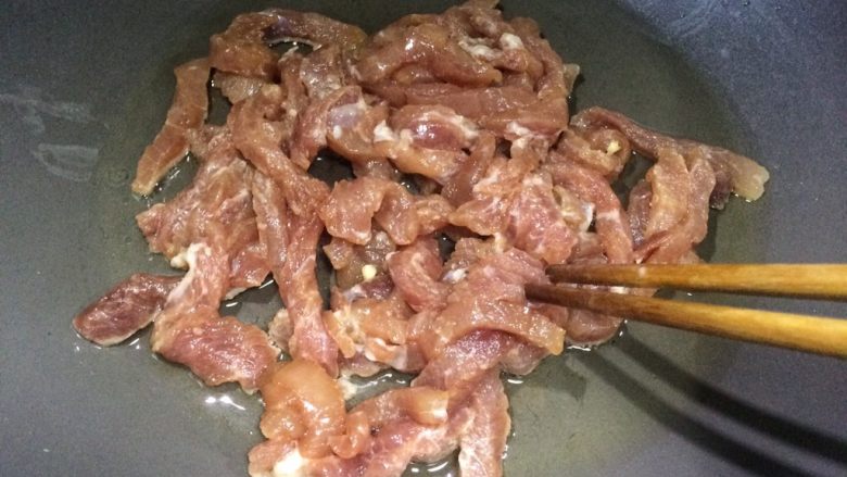 榨菜香干炒肉丝,适量油加热,倒入肉丝翻炒。