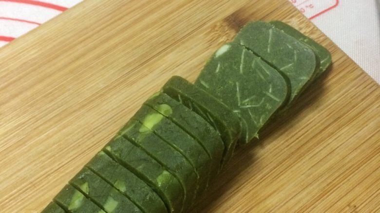 酥香可口的抹茶杏仁饼干,取出冻好的面团,切成厚度均匀(0.7厘米)的片片。
只要冷冻的硬度合适,一刀切下去,饼干的表面会很平滑。