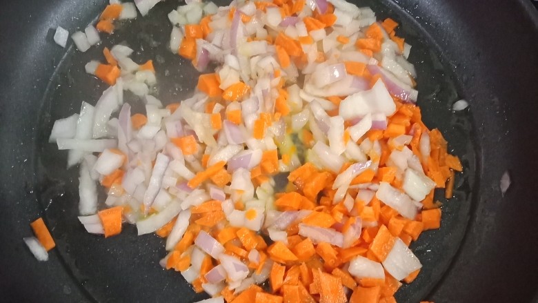 裙边蛋包饭,热锅后倒入油,烧热后倒入洋葱丁个红萝卜丁,翻炒,