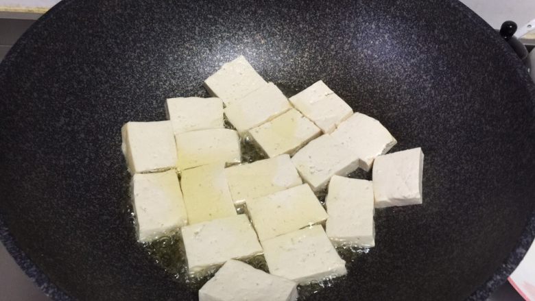 金针菇炖豆腐,锅里放油烧热,加入豆腐块