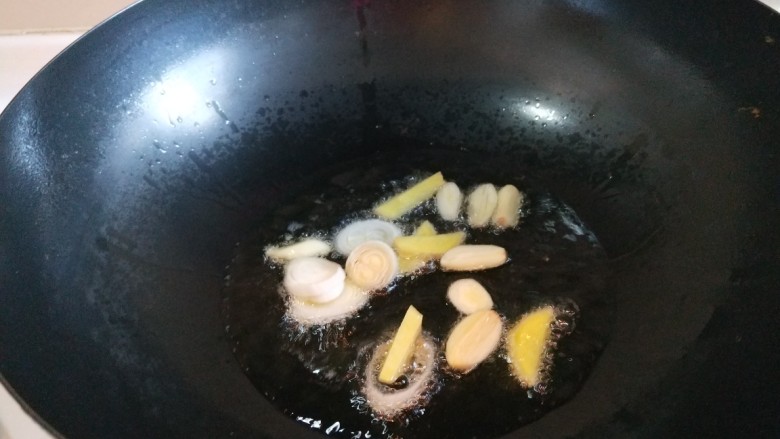家常五花肉炒饼,锅中放适量油烧热,放适量葱姜蒜炒香。