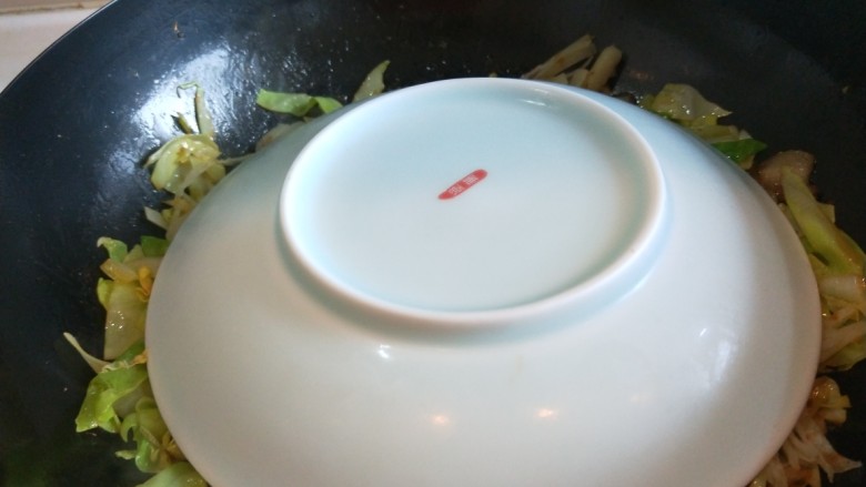 家常五花肉炒饼,倒入大饼丝不用翻炒,盖上一个盘子焖两分钟后翻炒均匀即可出锅。