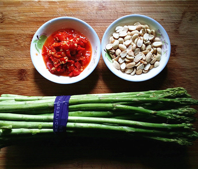 花生泡椒灼芦笋,备好食材；提前将花生放入一个食品袋中，用擀面杖来回轻轻压碎备用，<a style='color:red;display:inline-block;' href='/shicai/ 7079'>泡辣椒</a>用自己做的和超市买的都行