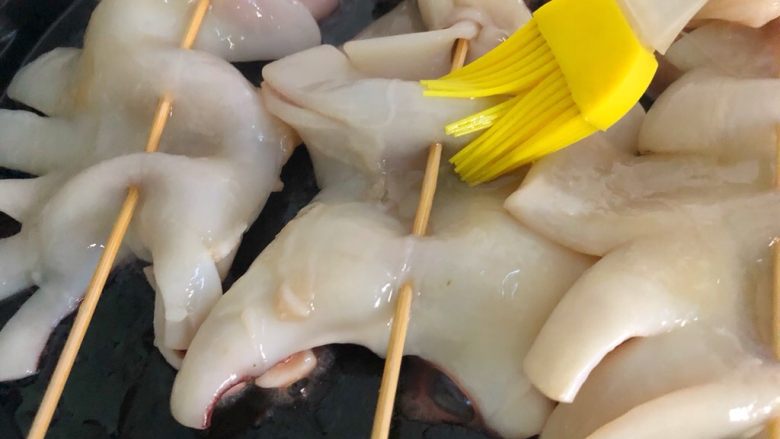 家常烤鱿鱼,放入鱿鱼串,在鱿鱼上也刷一层油