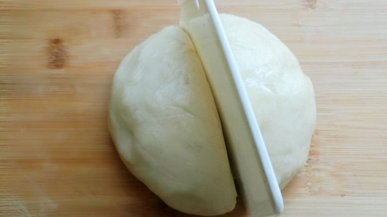 炸糖糕,取出醒好的面团,(不要再揉面,以防起筋,年糕会很硬的),用括刀分成两半。