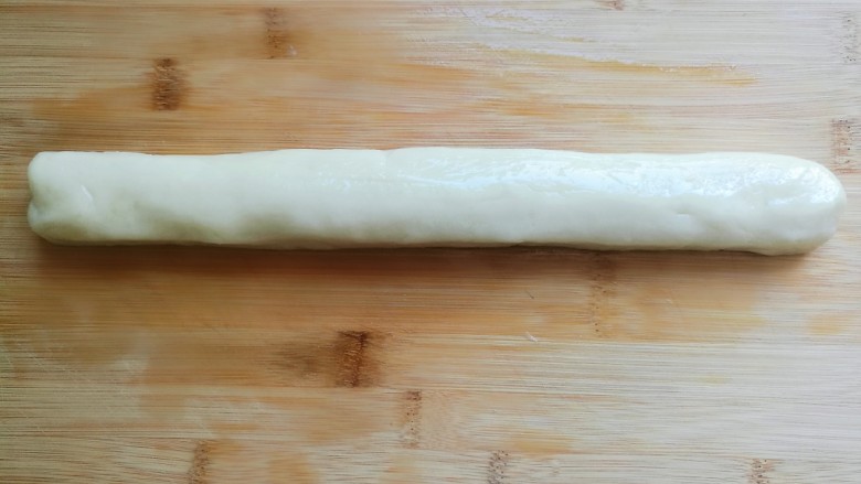 炸糖糕,取出一半面团,用手轻轻揉成长条。