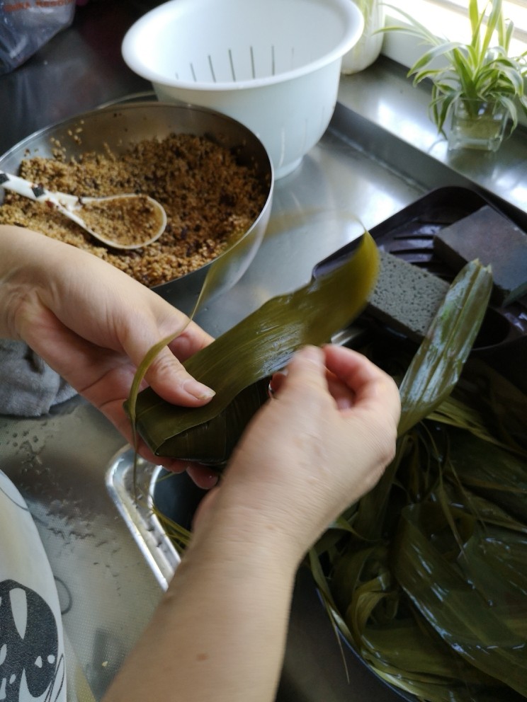 肉粽子,再拿一片粽叶
顺着角再包一层