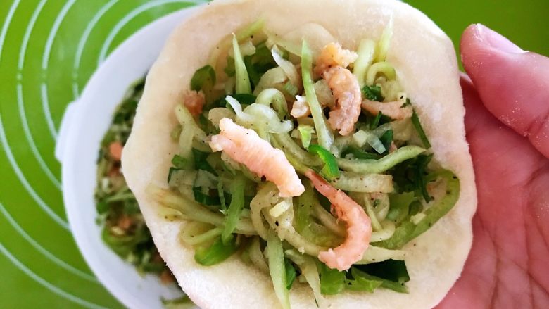 角瓜虾仁馅麦穗包子,取一个面皮,加入2勺角瓜虾仁馅料