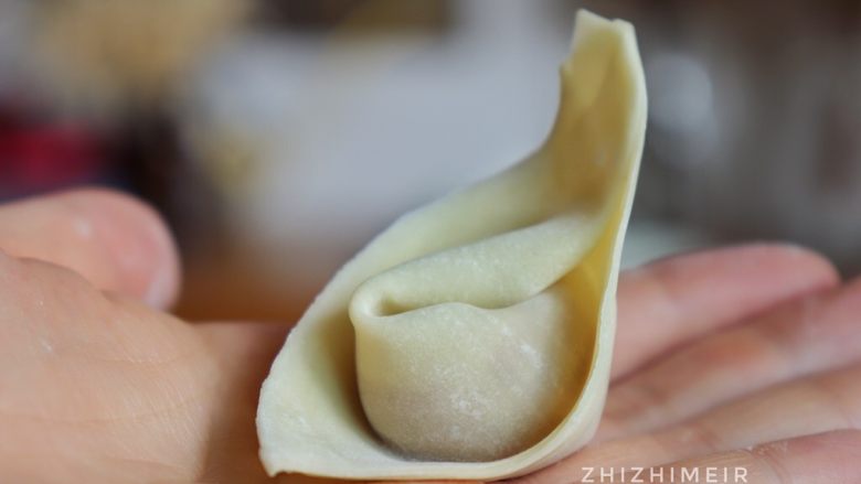 抄手的详细包法(附嫩滑肉馅做法),在朝外的一角涂上一点水,两角重合,捏紧即可。