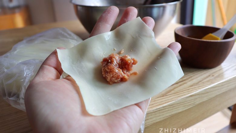 抄手的详细包法(附嫩滑肉馅做法),取一张抄手皮,放上适量肉馅,在相邻的两边用手沾一点点水涂上。