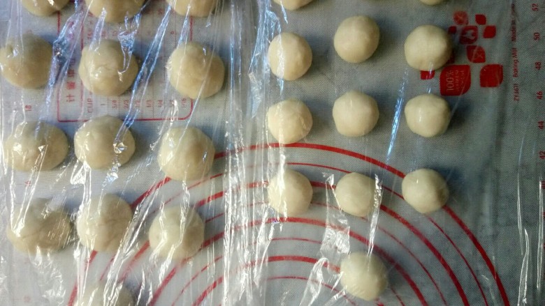老婆饼(豆沙版),将红豆沙馅分成25克一个,搓成10份待用。然后将油皮和油酥各分成10份,揉圆后盖上保鲜膜,防止表皮被吹干。