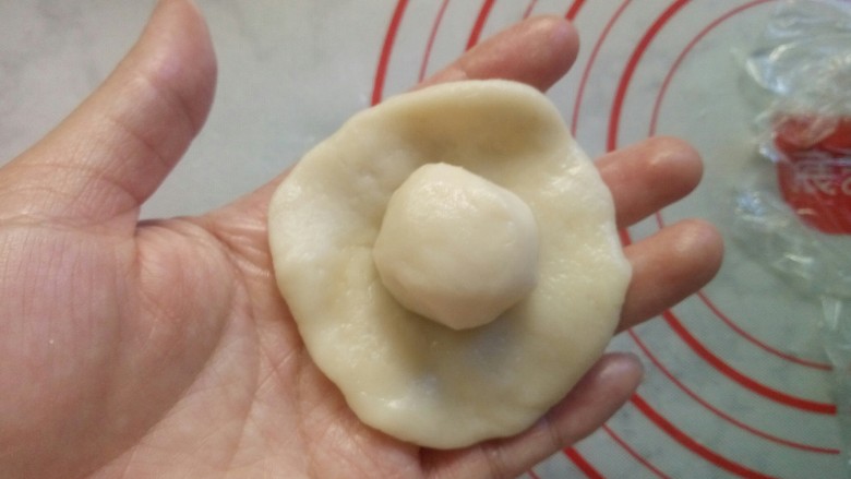 老婆饼(豆沙版),取一个油皮,摁扁后放入一个油酥。