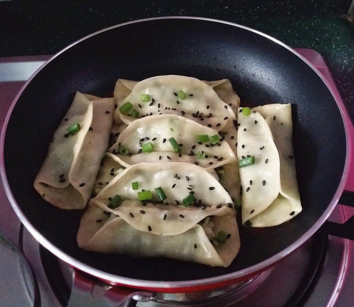 磷虾韭菜锅贴,待锅中水干时,开盖撒上葱沫和<a style='color:red;display:inline-block;' href='/shicai/ 668'>黑芝麻</a>关火