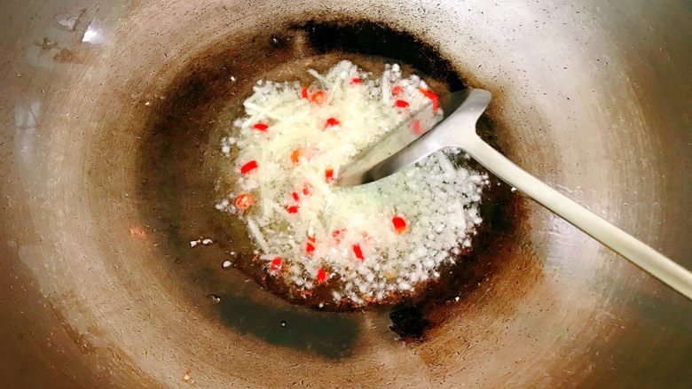 辣炒河蚬,锅中热油,放入姜、蒜、小辣椒,炒香。