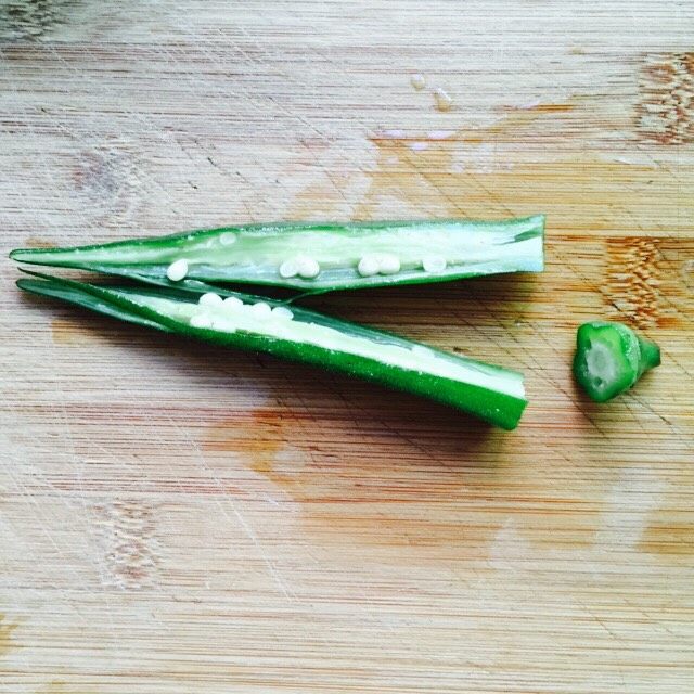 营养美味+金沙秋葵,将冰镇后的秋葵捞起沥干水分切掉蒂然后对半切开(如图所示)