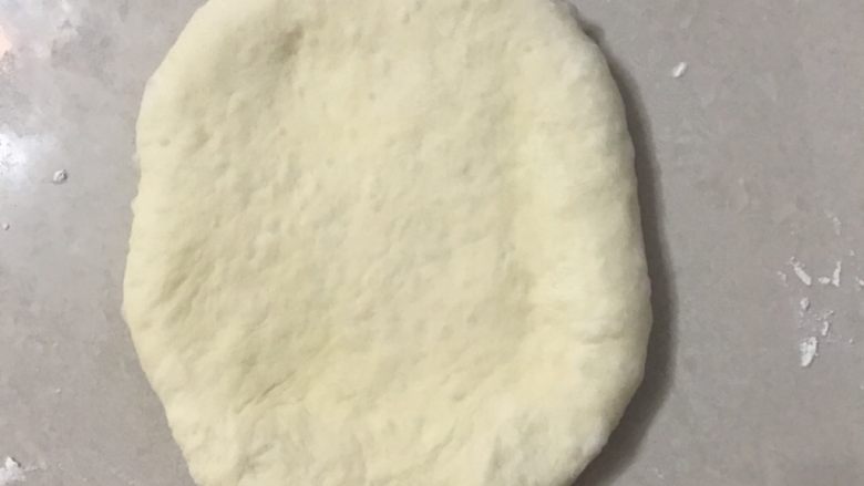 中种葡萄干排包,取一个面团按扁擀成长舌形。