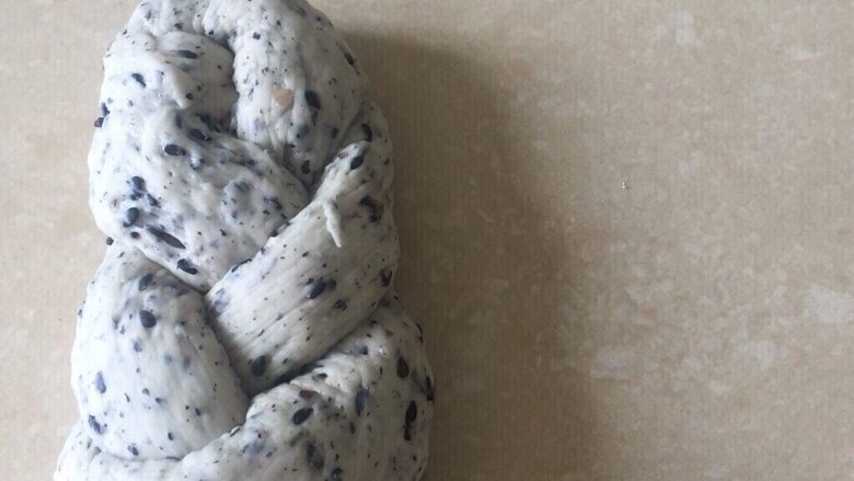 佛系养生黑芝麻辫子面包,第二十步:然后把左边的塞进洞口中整理好就好了