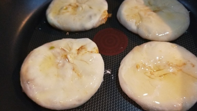 自创多味烧饼加驴肉,平底锅烧热放入火烧,上面刷一层油。