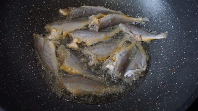 香煎小黄鱼,锅里热油后放入用厨房纸吸干水分的小黄鱼以中小火煎炸,少作翻动