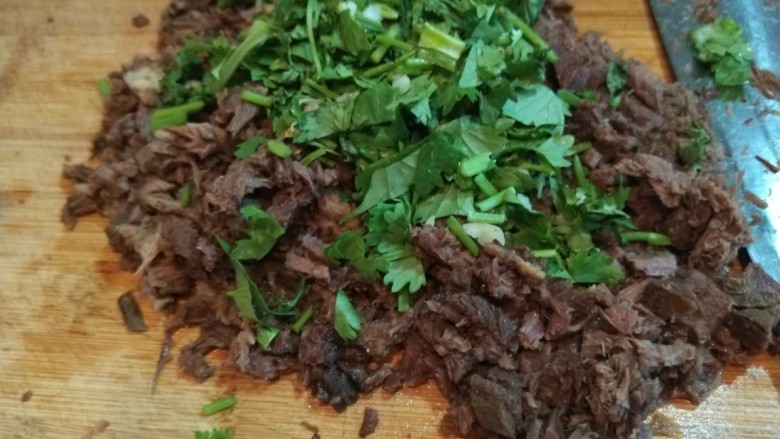 自创多味烧饼加驴肉,加入香菜一起剁碎,在加入适量汤汁不会干。