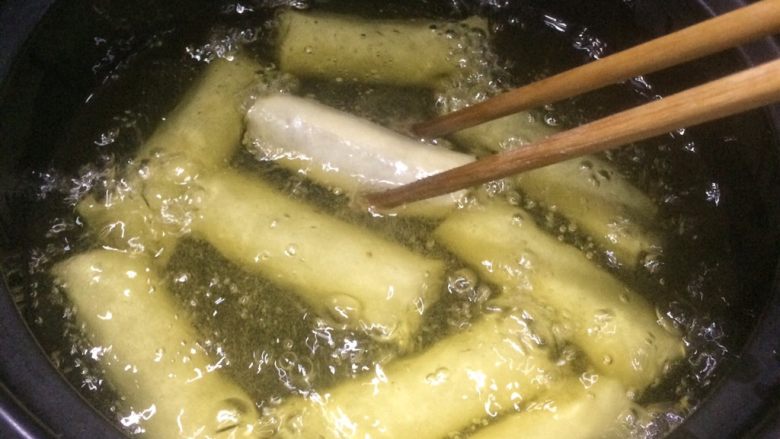 金色的红豆春卷,放入春卷中小火炸。
先炸30秒钟再用筷子翻面。