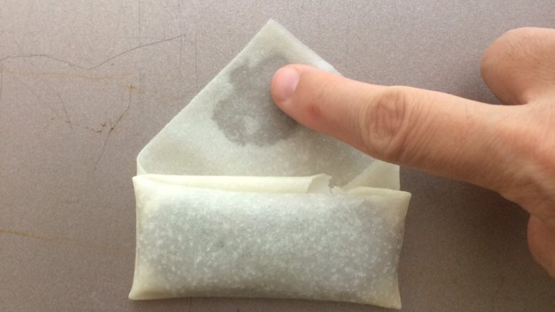 金色的红豆春卷,然后再向上卷一下,封口处抹上少许清水再包好就可以了。