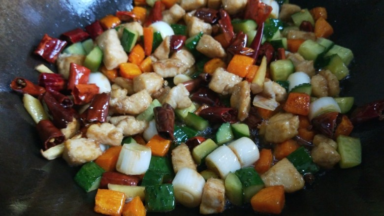 新文美食 家常宫爆鸡丁,倒入黄瓜,鸡丁,炸制好的<a style='color:red;display:inline-block;' href='/shicai/ 86474'>干辣椒</a>翻炒均匀。