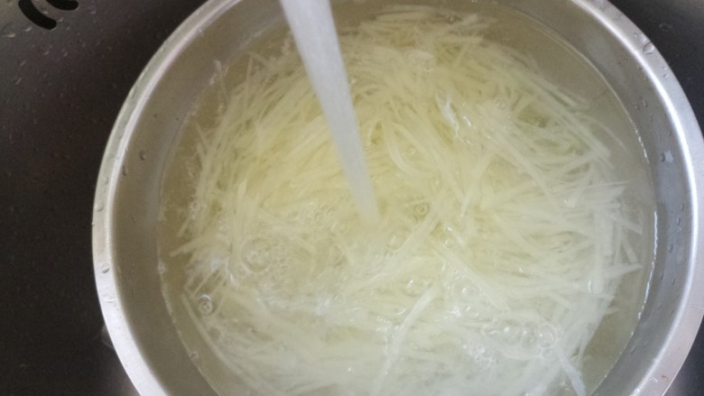 洋葱拌土豆丝,炒熟即可捞出,然后放在冷水里冲一下。