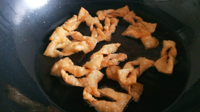 芝麻香酥脆麻花,炸制金黄酥脆捞出来控油。