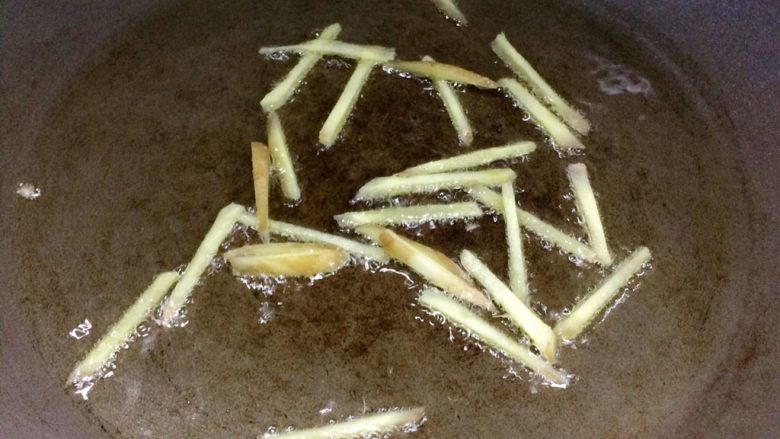 香煎带鱼,适量油加热,放入姜丝煎至焦黄后夹走。