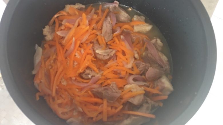 新疆手抓饭,将炒好的羊肉、胡萝卜洋葱放在米上,倒入适量热水,不要没过大米食材