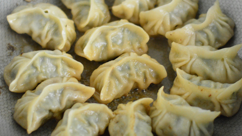 韭菜猪肉煎饺,待水分烧干,发出吱吱吱的声音即可关火