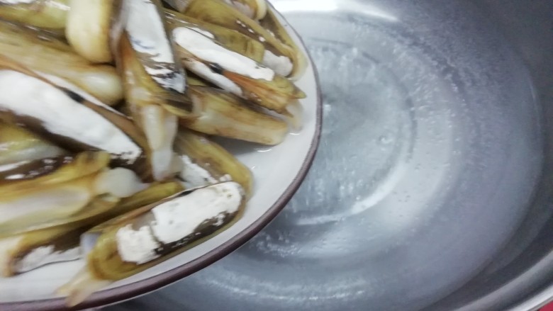 辣炒蛏子,汤锅里加入适量的水大火烧开,然后把圣子放入锅中焯水,炒到圣子壳全部自动开,而且会掉下来