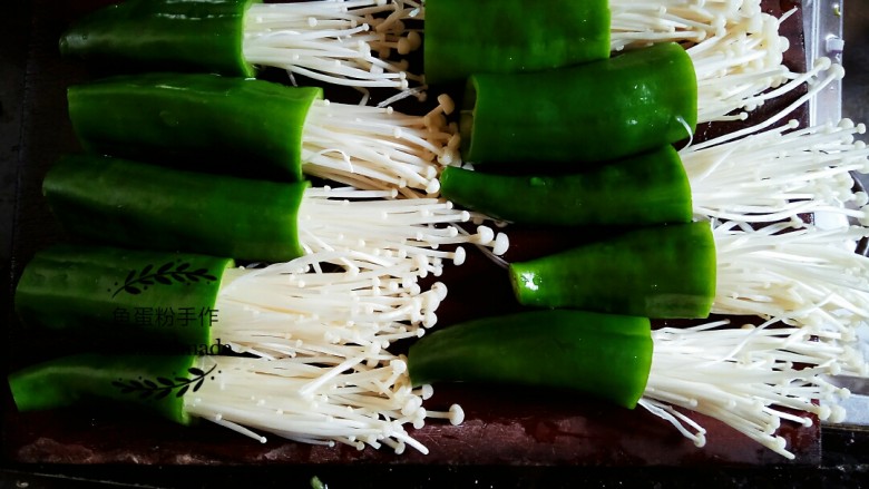 青椒金针菇,把上述准备好的金针菇和青椒组合起来,将金针菇插入到青椒里面可以插深一点,以免煎的时候会掉出来。