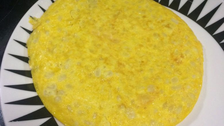 快手营养早餐:芝士甜玉米鸡蛋饼,然后将鸡蛋饼倒扣到碟子上。