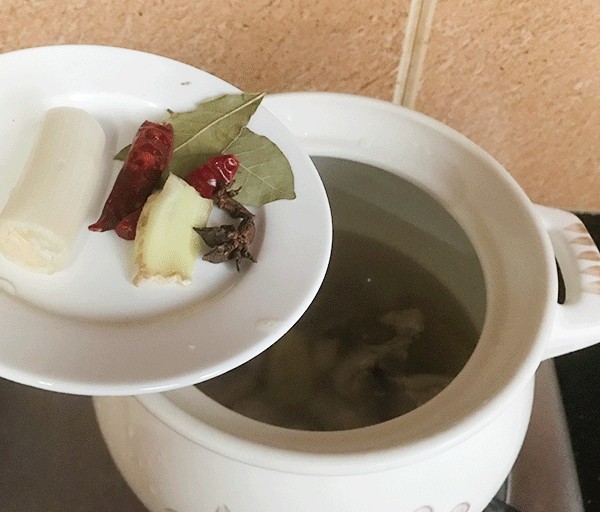 小鸡炖蘑菇,接着放香叶,八角,大葱,加食用油,料酒,酱油搅拌均匀。