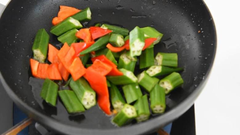 养身美食之秋葵山药烩腰果, 夏季推出正当时,热锅冷油,放入秋葵、红椒翻炒至断生。