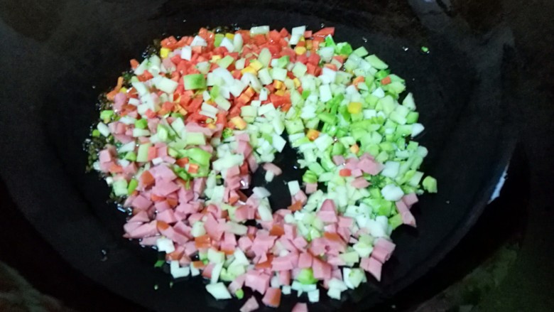 彩蔬饭团, 炒锅内倒适量的油烧热,爆香葱花,倒入蔬菜丁翻炒。